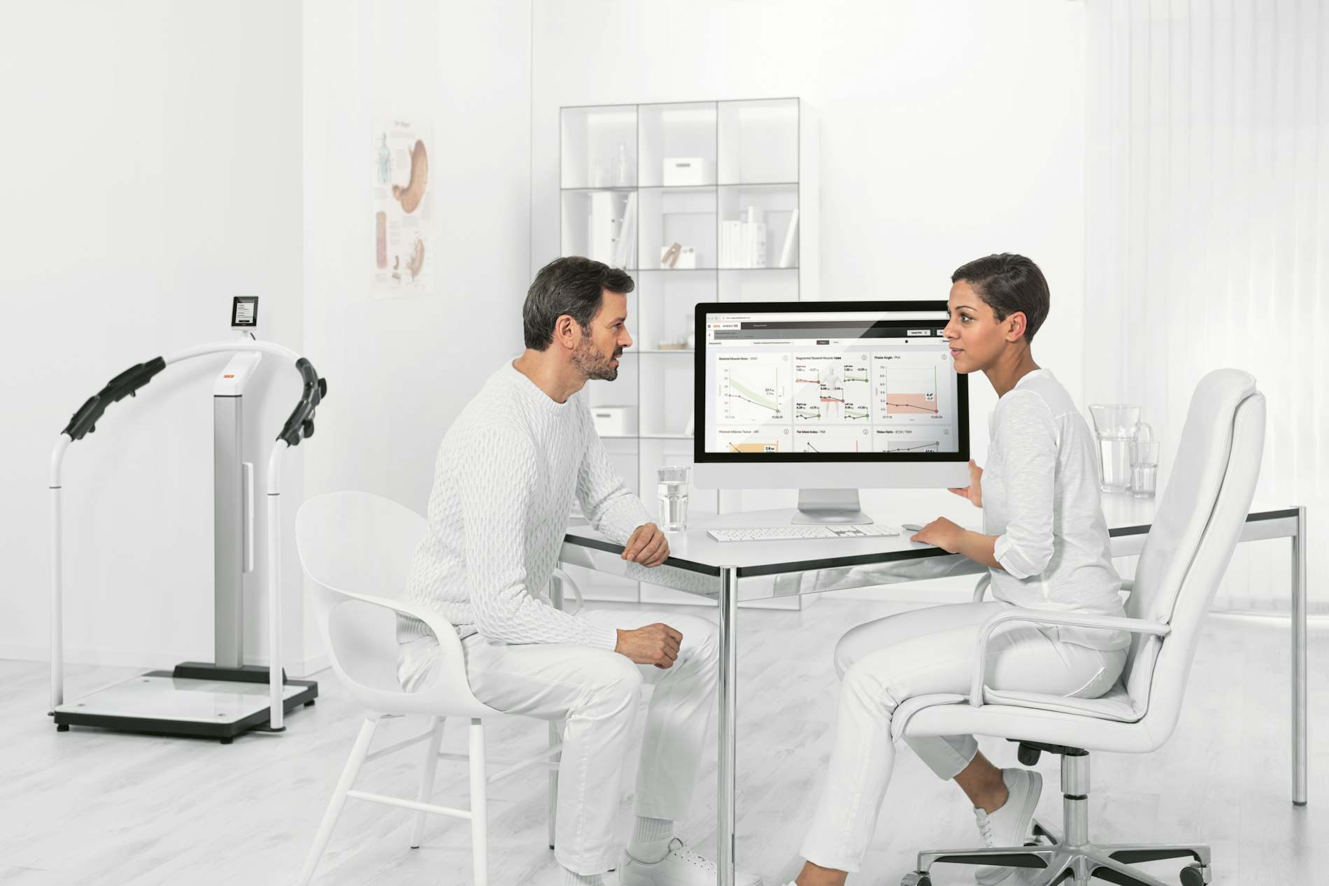 Médico e paciente conversando em consultório claro com computador